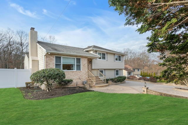 tri-level home with a front lawn