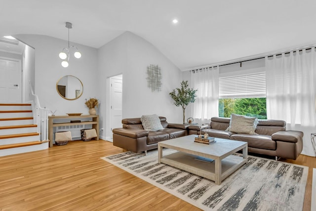 living room featuring a chandelier, hardwood / wood-style floors, and high vaulted ceiling