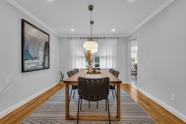 dining space featuring hardwood / wood-style floors and ornamental molding