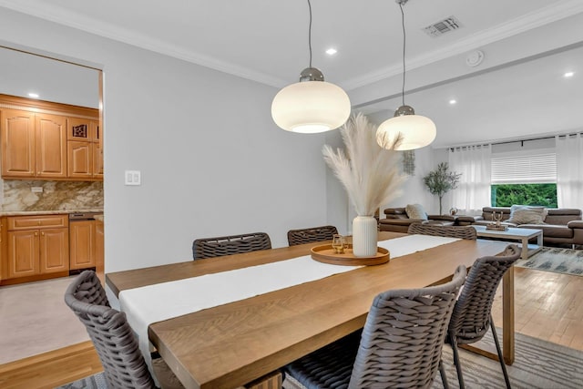 dining room with light hardwood / wood-style flooring and crown molding