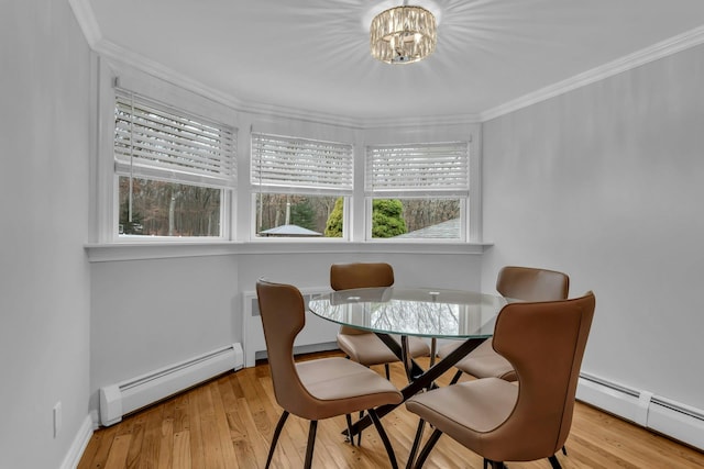 dining space with a chandelier, light wood-type flooring, a baseboard radiator, and crown molding