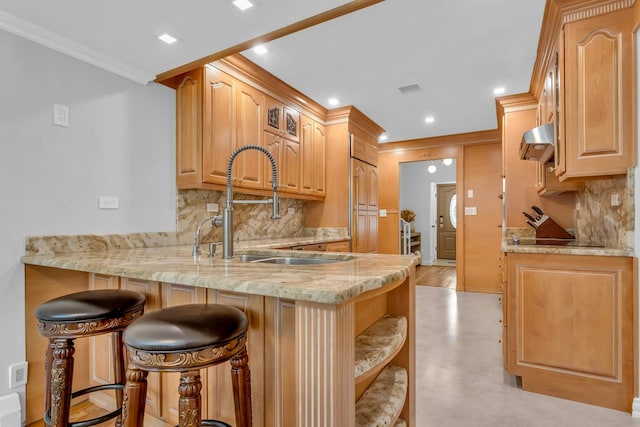 kitchen with a kitchen breakfast bar, crown molding, kitchen peninsula, and backsplash