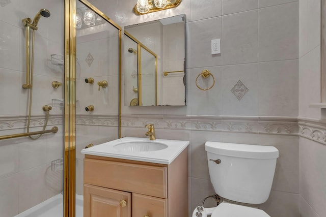 bathroom with vanity, toilet, a shower with door, and tile walls