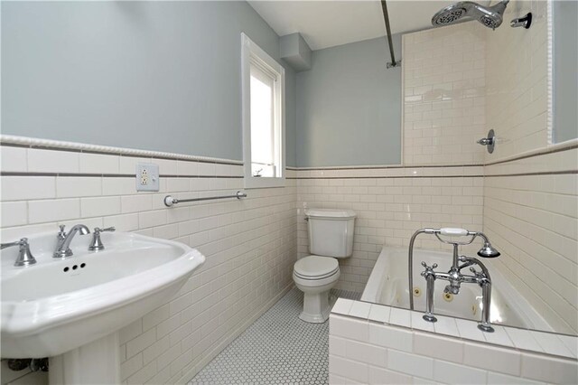 full bathroom with sink, tile walls, and tile patterned flooring