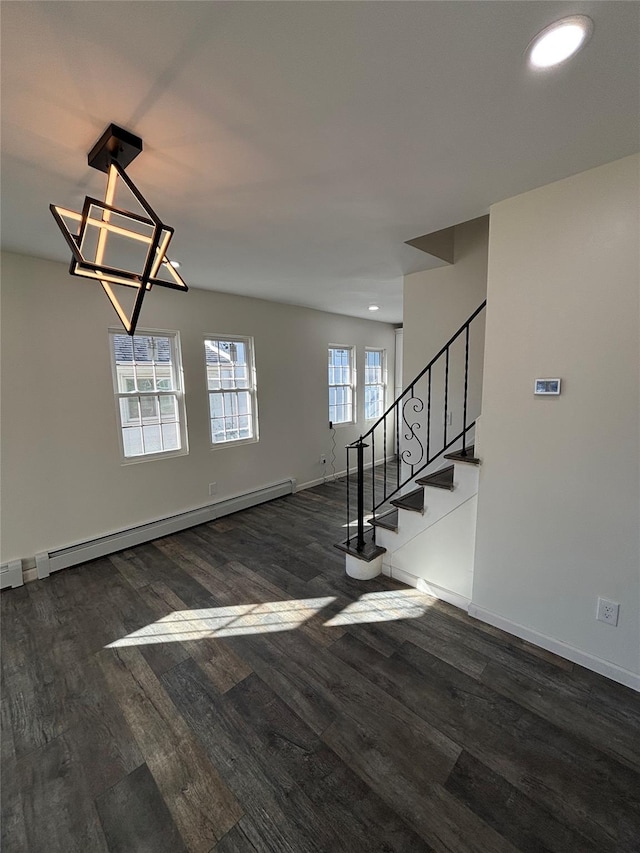 interior space with stairs, baseboard heating, wood finished floors, and baseboards