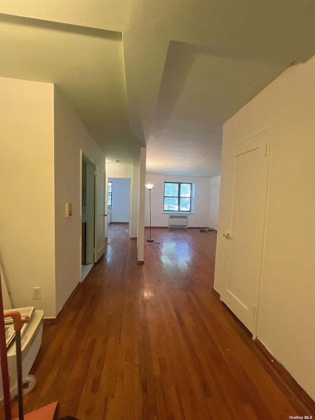 hall with radiator and dark hardwood / wood-style flooring