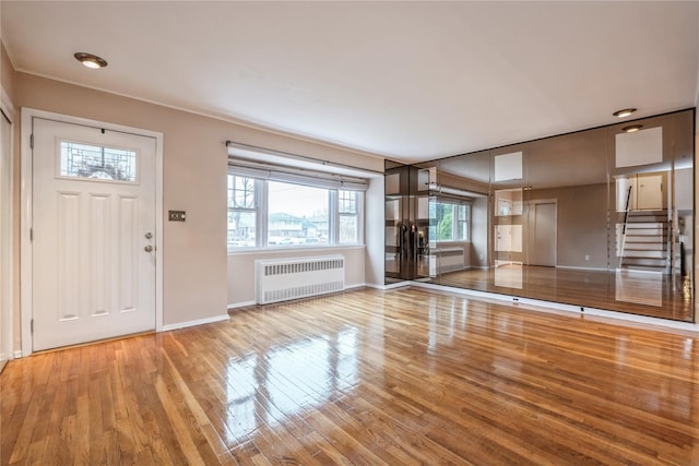 foyer featuring radiator heating unit and wood-type flooring