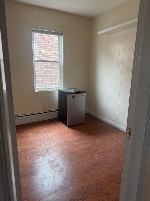 95-07 239th St, Floral Park, NY 11001 - spare room with wood finished floors and a baseboard radiator