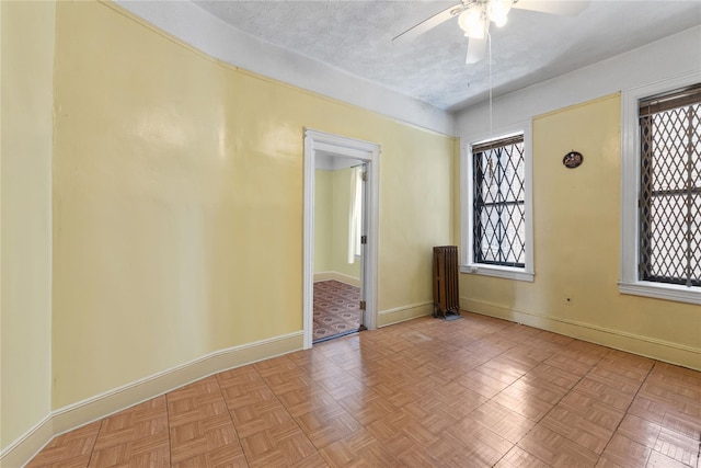 unfurnished room with plenty of natural light, a textured ceiling, and light parquet flooring