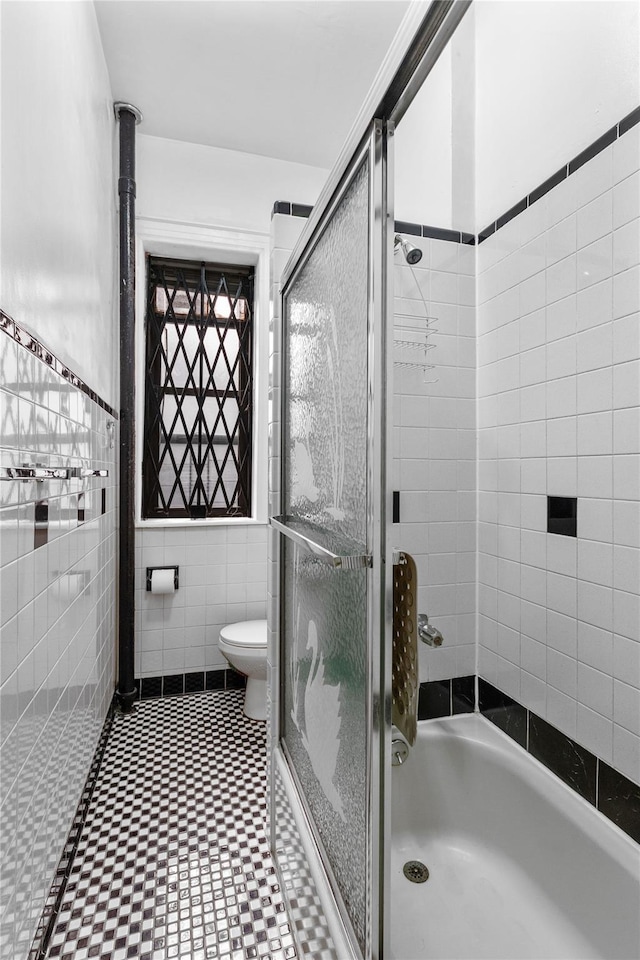 bathroom featuring tile walls and toilet