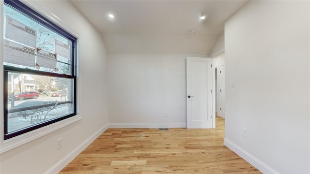 unfurnished room with light hardwood / wood-style floors and vaulted ceiling