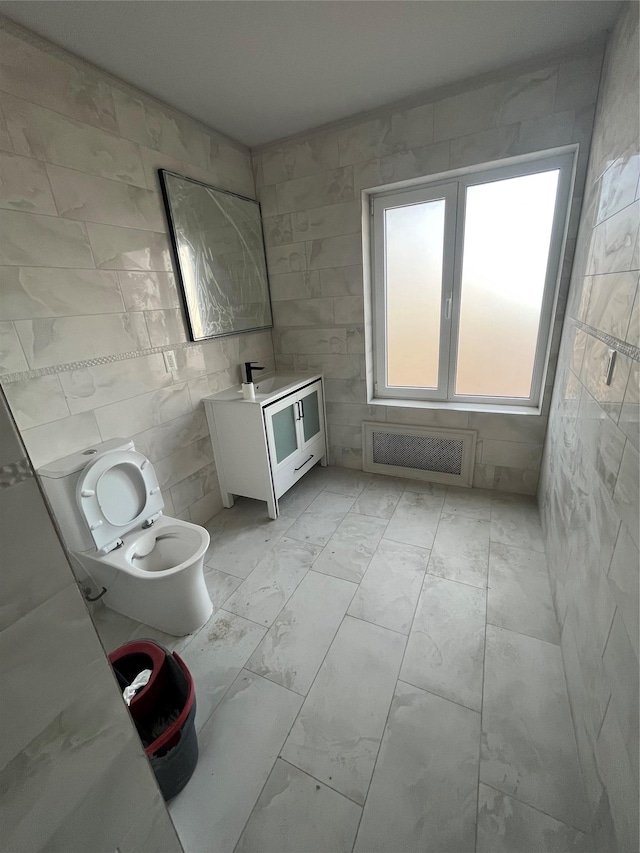 bathroom with vanity, tile walls, and toilet