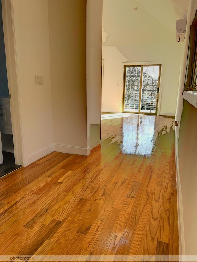 unfurnished room featuring light hardwood / wood-style flooring and vaulted ceiling