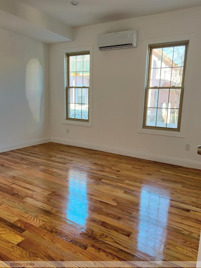 empty room featuring light wood-type flooring and a wall unit AC