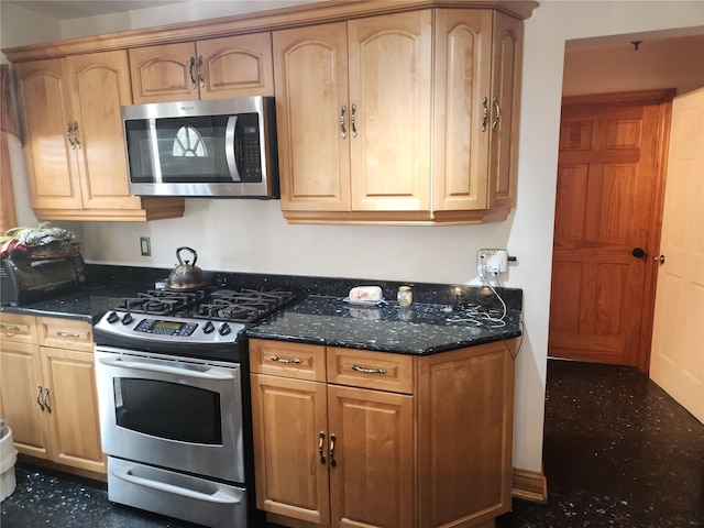 kitchen with dark stone countertops and stainless steel appliances