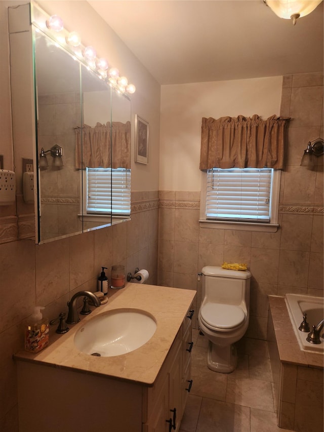 bathroom with a washtub, tile patterned flooring, toilet, vanity, and tile walls