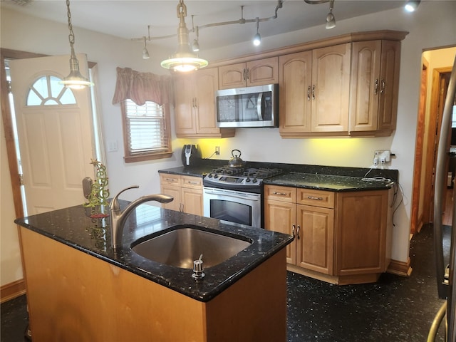 kitchen featuring decorative light fixtures, dark stone countertops, sink, and appliances with stainless steel finishes