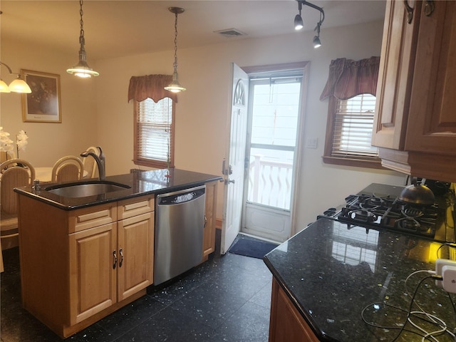 kitchen with decorative light fixtures, stainless steel dishwasher, dark stone counters, and sink