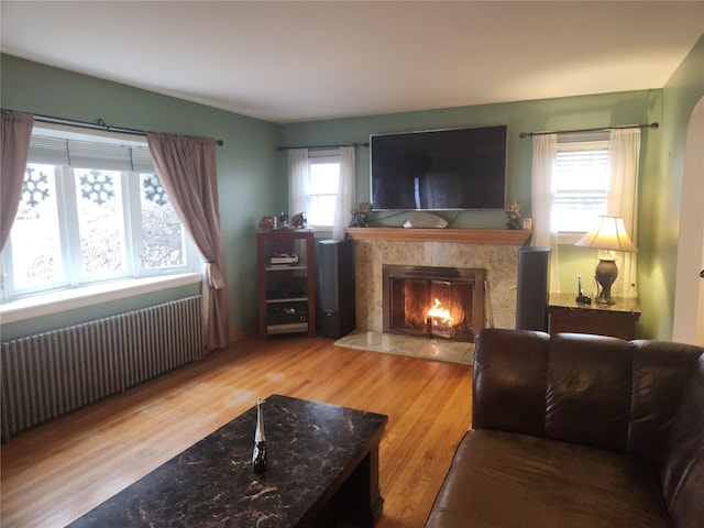 living room with radiator, a fireplace, and hardwood / wood-style floors