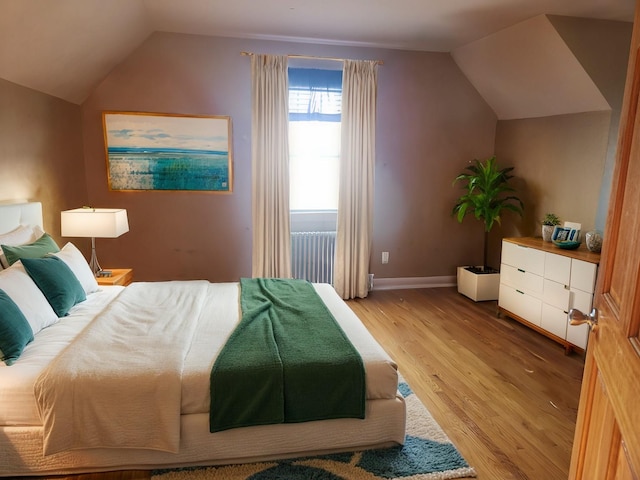 bedroom featuring hardwood / wood-style floors and vaulted ceiling