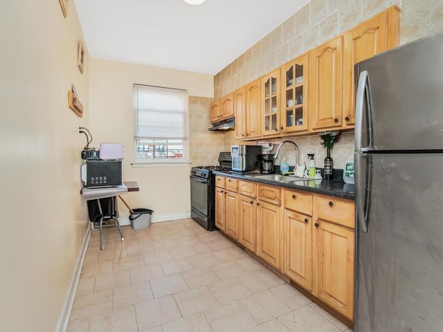 kitchen featuring black gas range, stainless steel fridge, sink, and tasteful backsplash