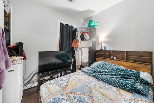 bedroom with dark hardwood / wood-style floors and a baseboard radiator