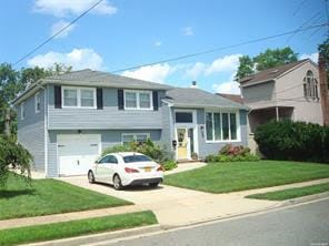 view of front of property featuring a garage and a front lawn