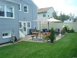 rear view of house featuring a yard and a patio