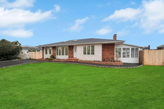 view of front of property with a sunroom and a front yard