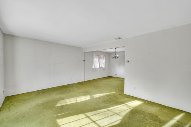 unfurnished room with carpet flooring and an inviting chandelier