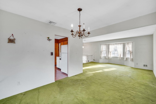 empty room with carpet and a chandelier