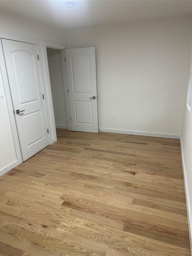 unfurnished room with light wood-type flooring