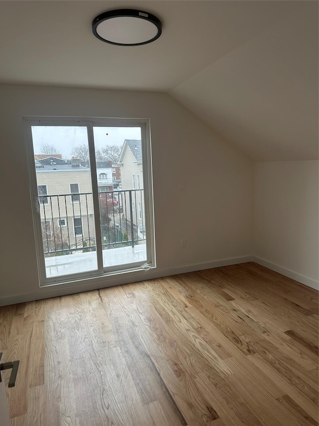 additional living space featuring light hardwood / wood-style floors and lofted ceiling