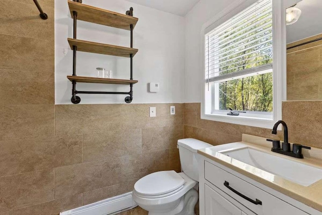 bathroom with vanity, tile walls, and toilet
