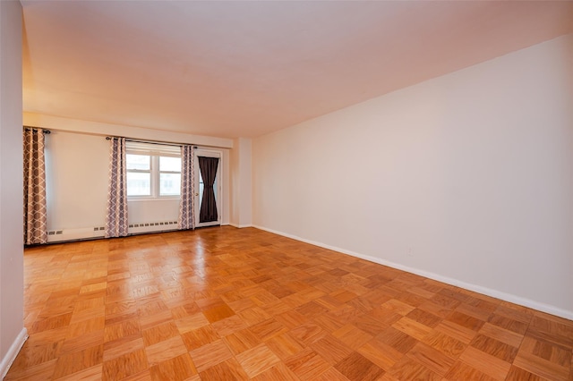 spare room with baseboard heating and light parquet floors