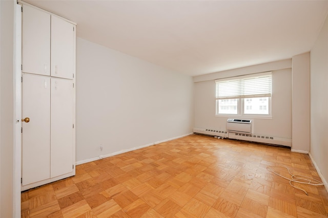 empty room featuring light parquet flooring and an AC wall unit