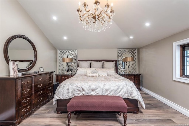 bedroom featuring light hardwood / wood-style floors, an inviting chandelier, and lofted ceiling