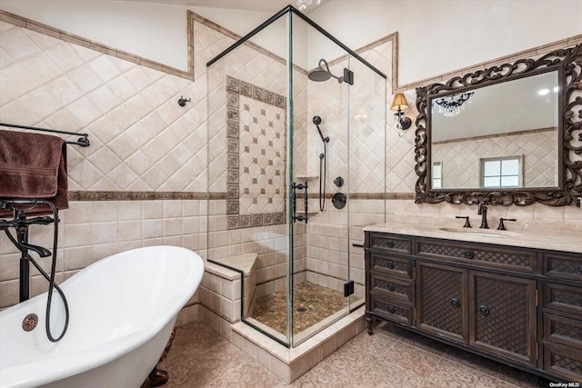 bathroom with tile patterned flooring, vanity, independent shower and bath, and tile walls