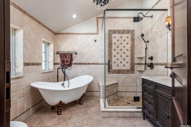 bathroom featuring vanity, vaulted ceiling, tile patterned flooring, tile walls, and independent shower and bath