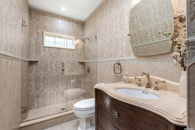 bathroom with an enclosed shower, vanity, tile walls, tile patterned flooring, and toilet