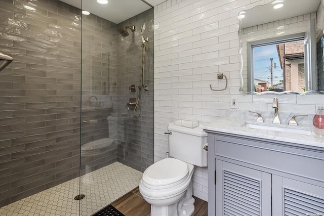 bathroom with hardwood / wood-style floors, vanity, an enclosed shower, and toilet