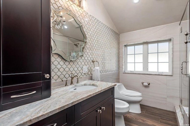 bathroom featuring hardwood / wood-style floors, a bidet, vaulted ceiling, and tile walls