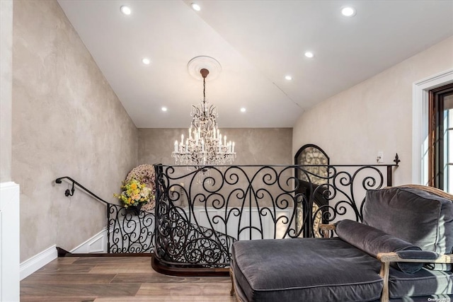 living area featuring wood-type flooring, lofted ceiling, and an inviting chandelier