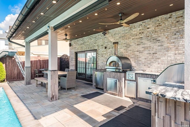 view of patio / terrace with an outdoor kitchen, ceiling fan, and grilling area