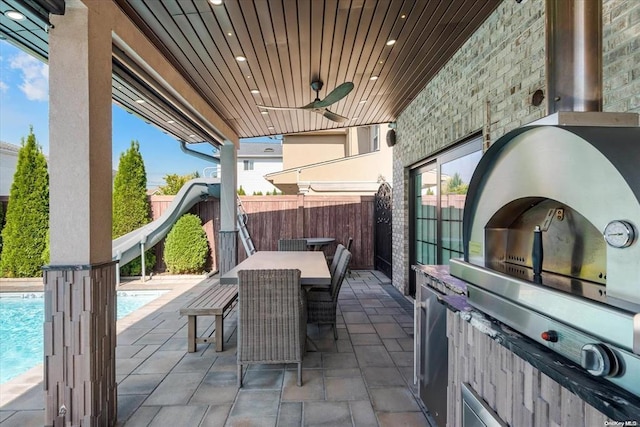 view of patio / terrace featuring ceiling fan, area for grilling, and a fenced in pool