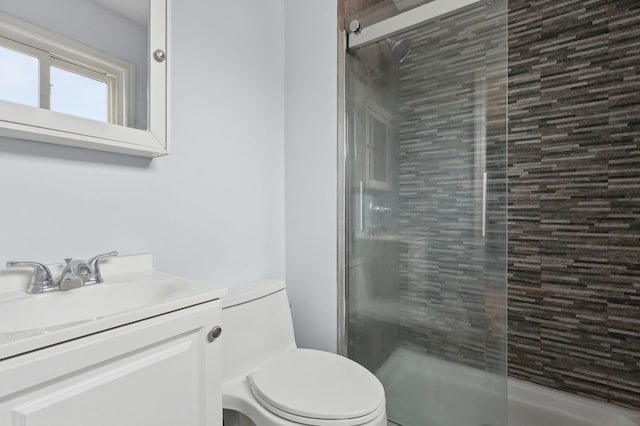 bathroom with an enclosed shower, vanity, and toilet