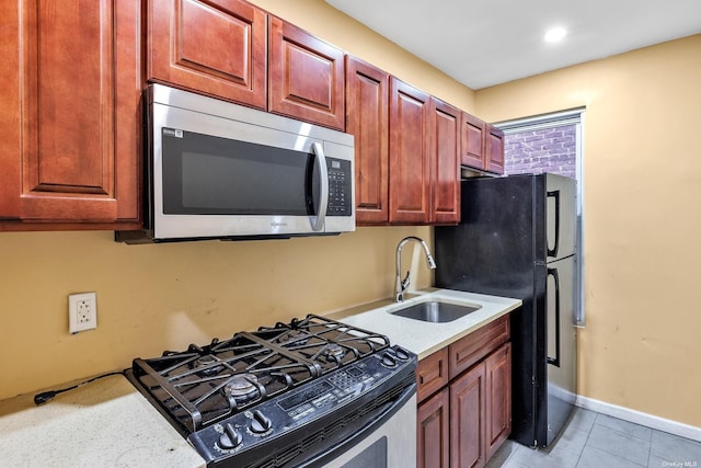 kitchen featuring sink, light tile patterned flooring, and black appliances