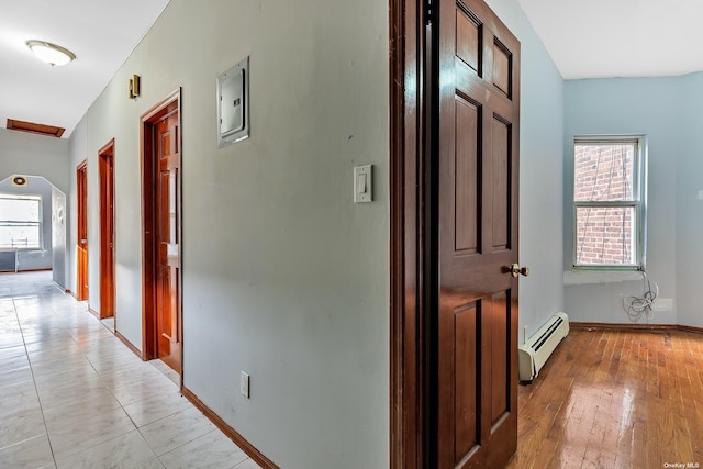 hall featuring plenty of natural light, light hardwood / wood-style flooring, and a baseboard heating unit