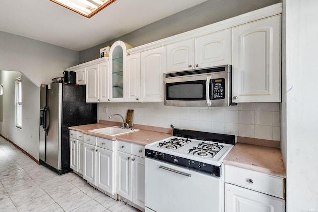 kitchen featuring appliances with stainless steel finishes, tasteful backsplash, white cabinetry, and sink