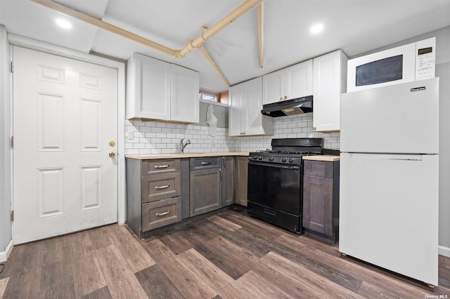 kitchen with white cabinets, decorative backsplash, dark hardwood / wood-style floors, white fridge, and gas stove